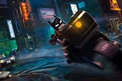Lego Batman riding on a motorbike around Gotham.